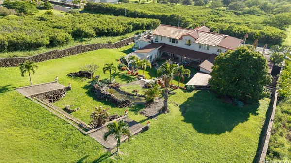 an aerial view of a house with a garden and lake view