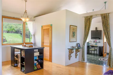 a room with kitchen island stainless steel appliances furniture and a flat screen tv