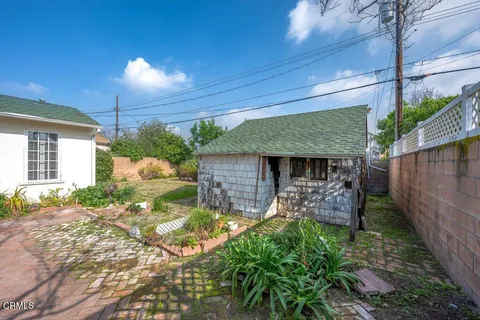 a view of a backyard with table and chairs potted plants and a ceiling fan