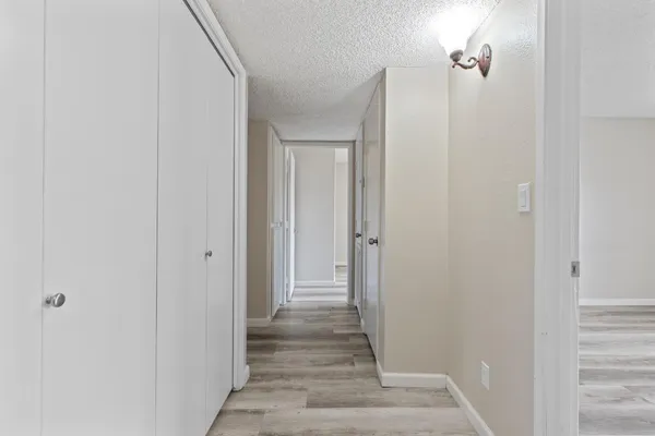 a view of a hallway with wooden floor and entryway