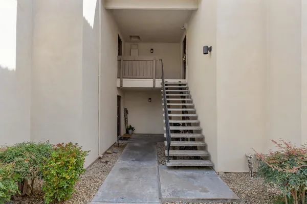 a view of a hallway with stairs and wooden floor