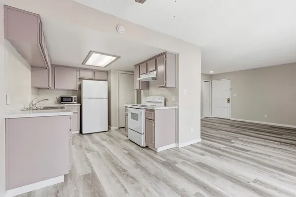 a kitchen with white cabinets and white appliances