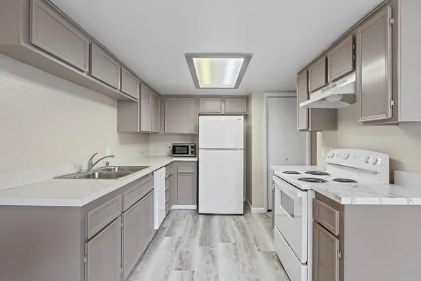 a kitchen with a sink a stove a refrigerator and a refrigerator