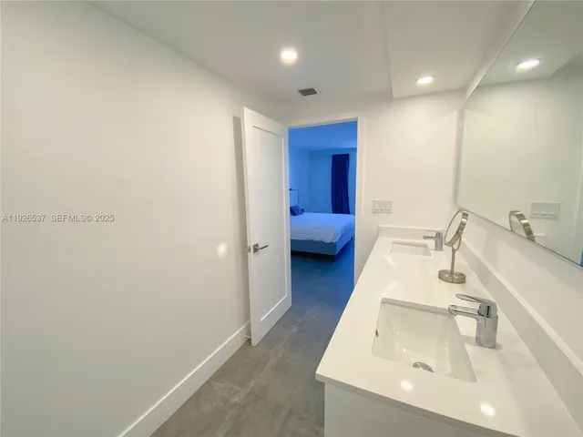 a hallway with white cabinets and wooden floor