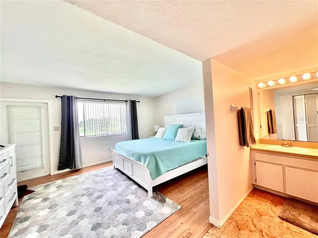 a spacious bedroom with a bed and a large window