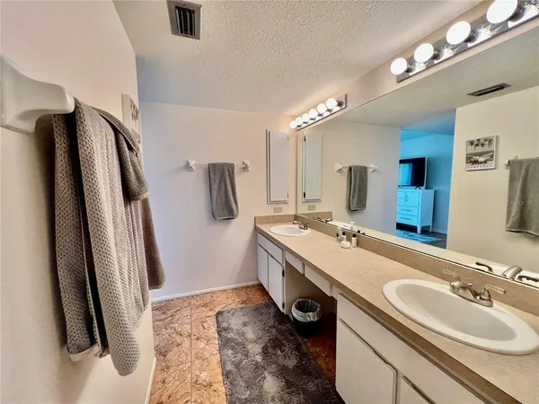 a bathroom with double vanity and a mirror