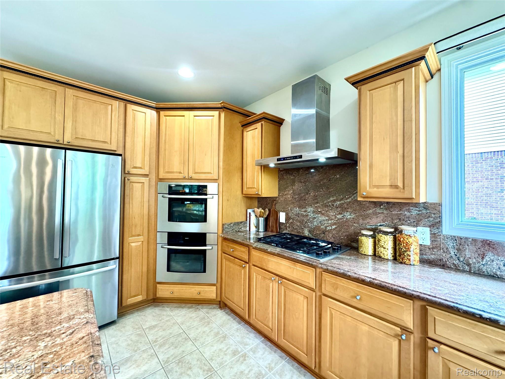 1215 Letica Drive Rochester, MI 48307 - Photo 10 of 43 Kitchen featuring stainless steel appliances, dark stone countertops, light tile patterned floors, backsplash, and recessed lighting