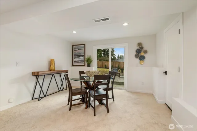 a view of a dining room and livingroom with furniture a rug a fireplace and a chandelier