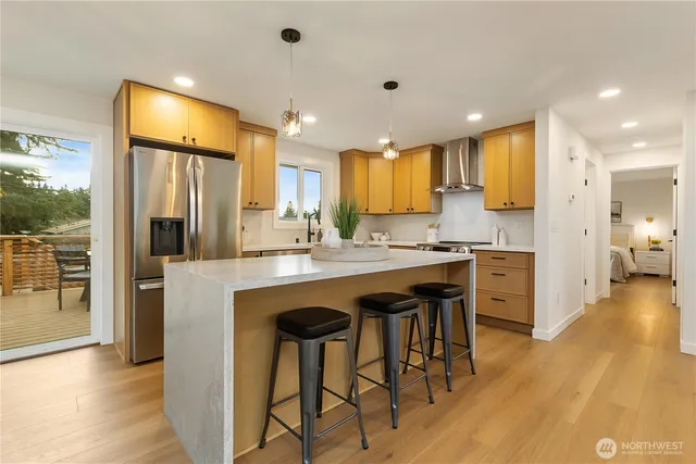 a kitchen with stainless steel appliances granite countertop a refrigerator and a stove top oven