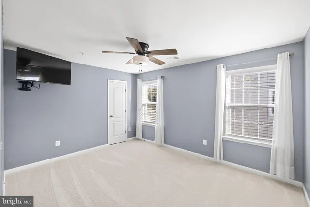 a view of a livingroom with a ceiling fan and window