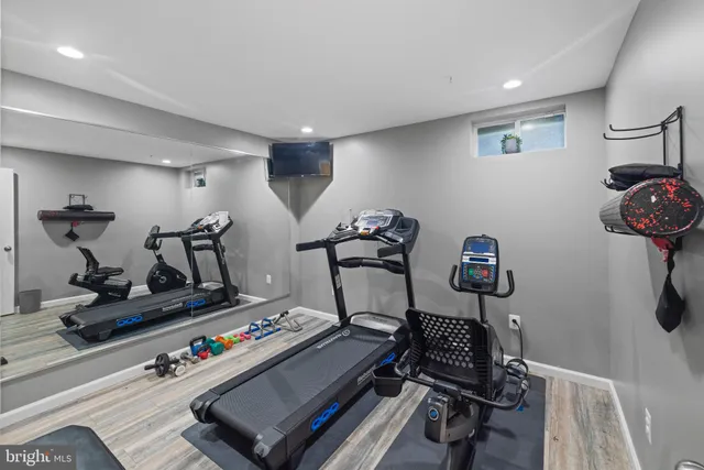 a room with gym equipment and wooden floor