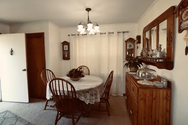 a view of a dining room with furniture and chandelier