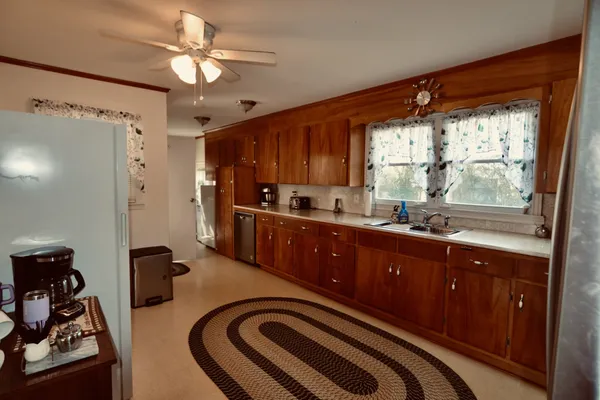 a kitchen with stainless steel appliances kitchen island granite countertop a refrigerator and a sink