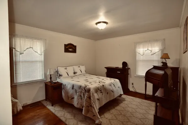 a bedroom with a bed and wooden floor