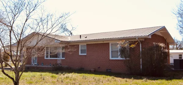 a front view of a house with a yard covered with snow