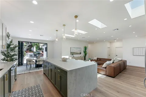 a large kitchen with kitchen island a large counter top space a sink and stainless steel appliances