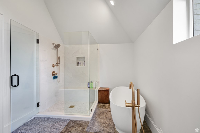 180 Farm Road Midway, UT 84049 - Photo 46 of 99 Freestanding soaking tub with a floor-mounted brass faucet, glass-enclosed shower with a rain shower head, and tile flooring
