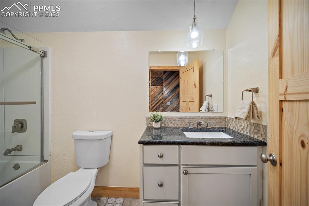 10739 Arnold Lane Rye, CO 81069 - Photo 27 of 50 a bathroom with a granite countertop sink vanity mirror and toilet