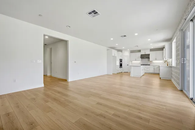 a view of kitchen with refrigerator stove and white cabinets