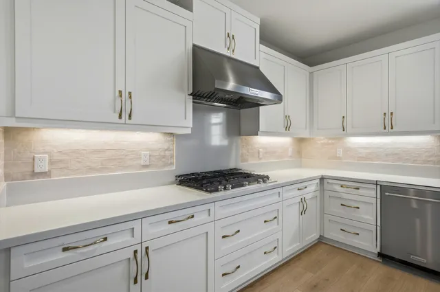 a kitchen with white cabinets and appliances
