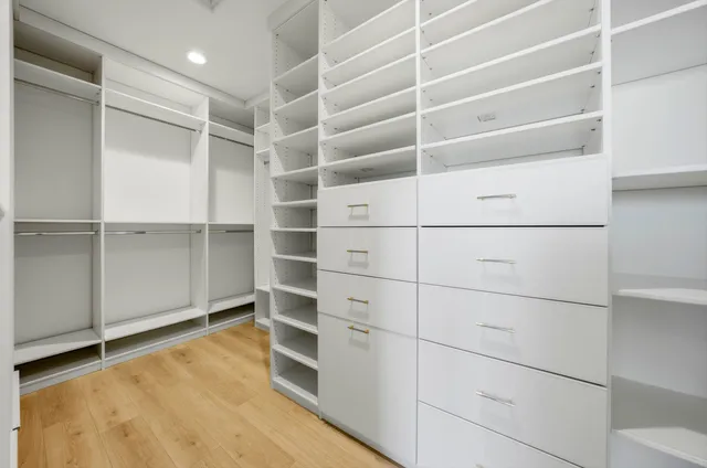 a view of walk in closet with empty racks