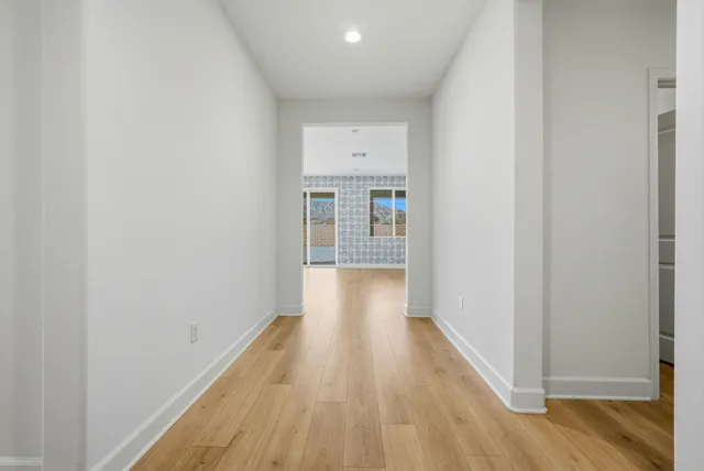 a view of a hallway with wooden floor