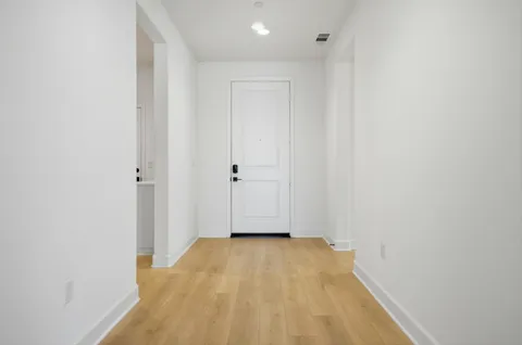 a view of a room with wooden floor and white wall