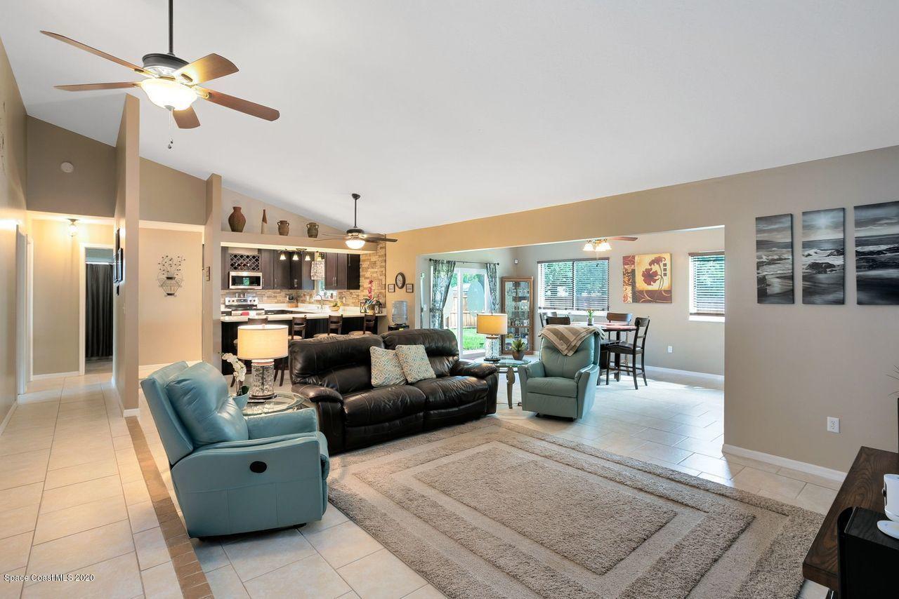 689 Bryant Road Palm Bay, FL 32908 - Photo 13 of 27 a living room with furniture kitchen view and a chandelier