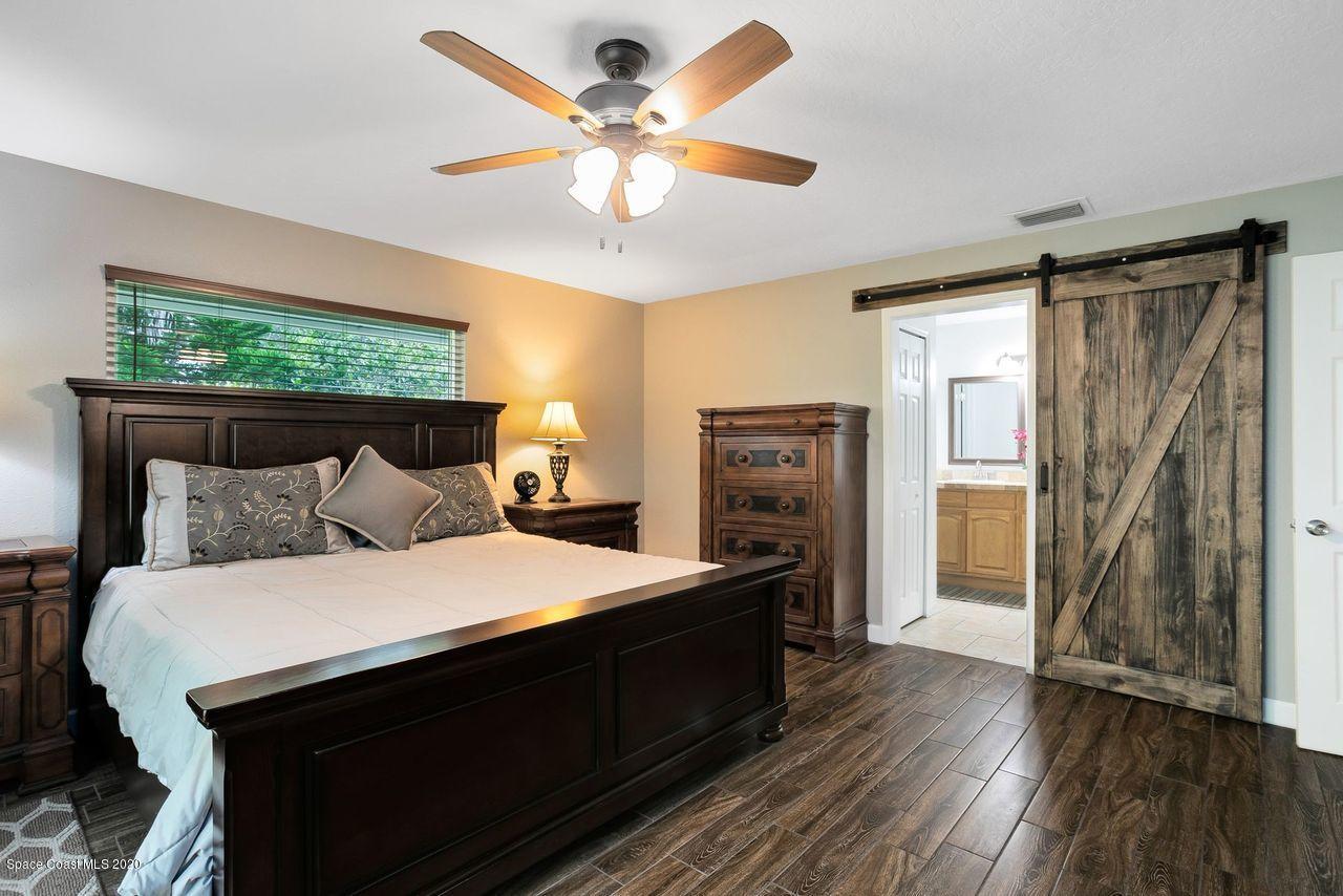689 Bryant Road Palm Bay, FL 32908 - Photo 15 of 27 a bedroom with a bed and a chandelier