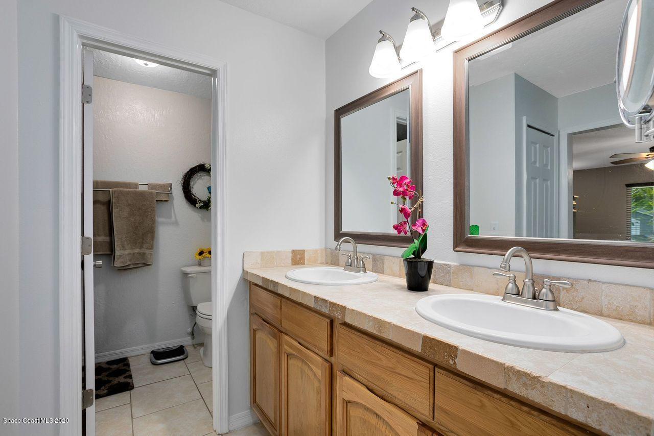 689 Bryant Road Palm Bay, FL 32908 - Photo 18 of 27 a bathroom with a double vanity sink mirror and toilet