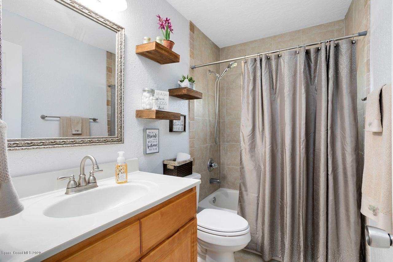 689 Bryant Road Palm Bay, FL 32908 - Photo 21 of 27 a bathroom with a sink a toilet and a mirror