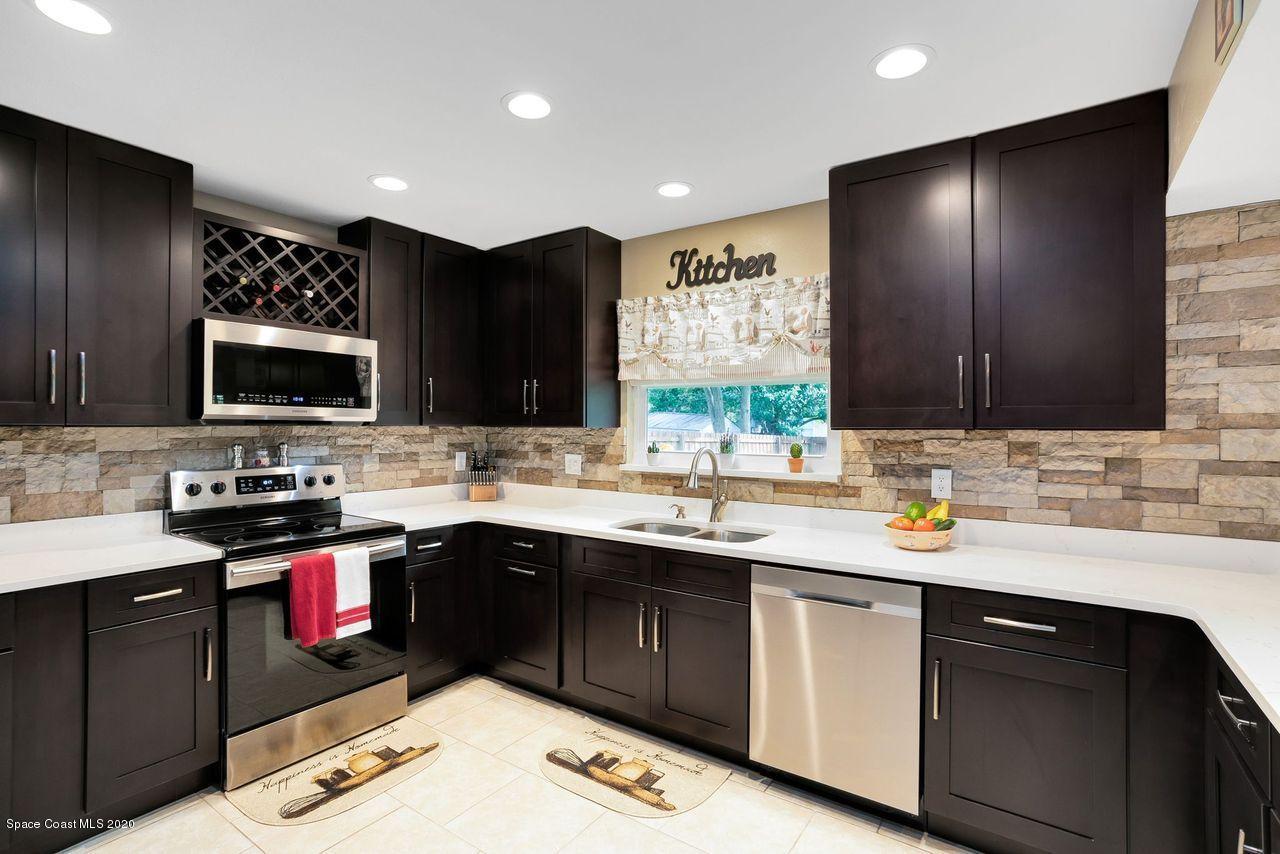 689 Bryant Road Palm Bay, FL 32908 - Photo 6 of 27 a kitchen with a sink stove and microwave