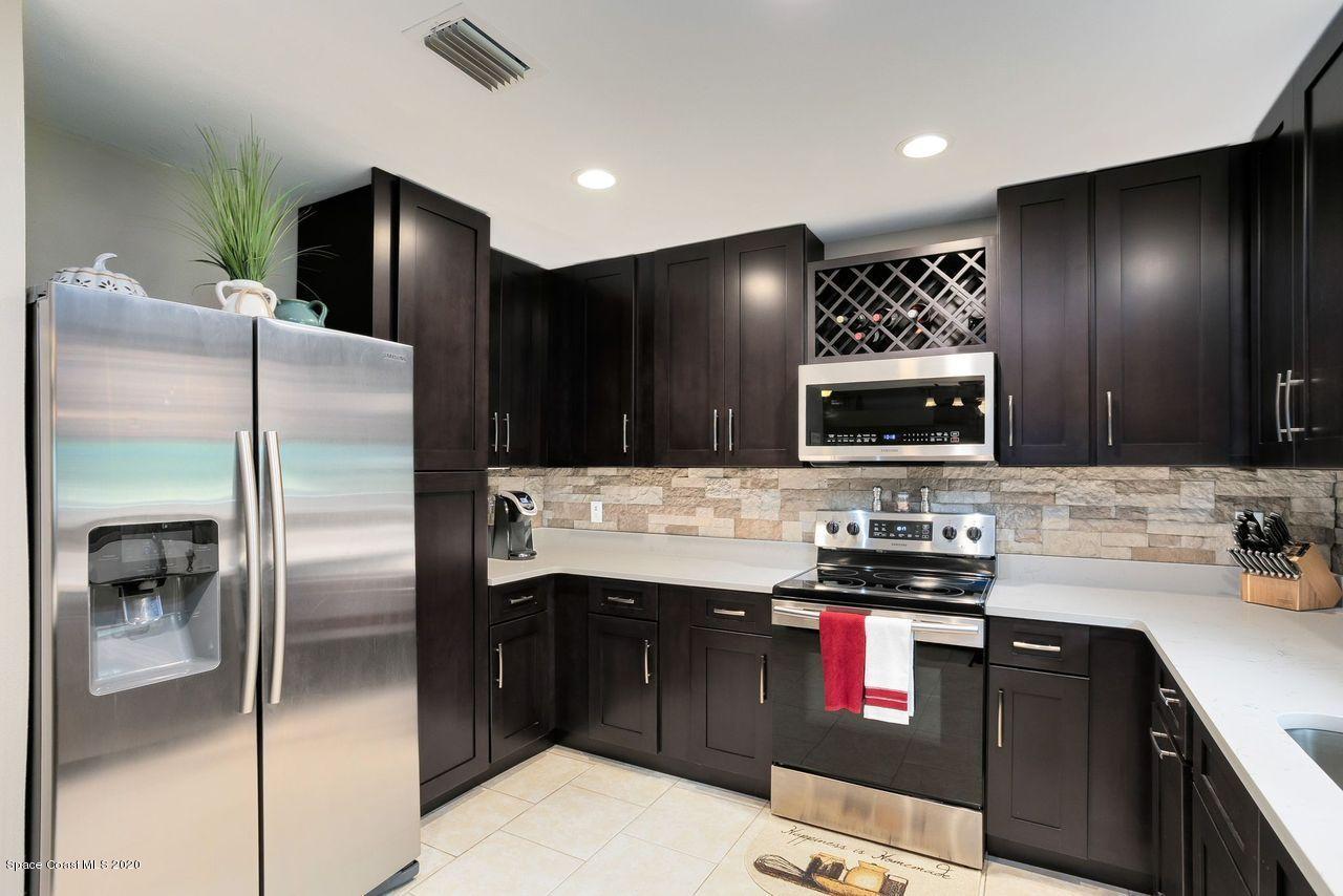 689 Bryant Road Palm Bay, FL 32908 - Photo 7 of 27 a kitchen with stainless steel appliances kitchen island granite countertop a refrigerator and a stove top oven