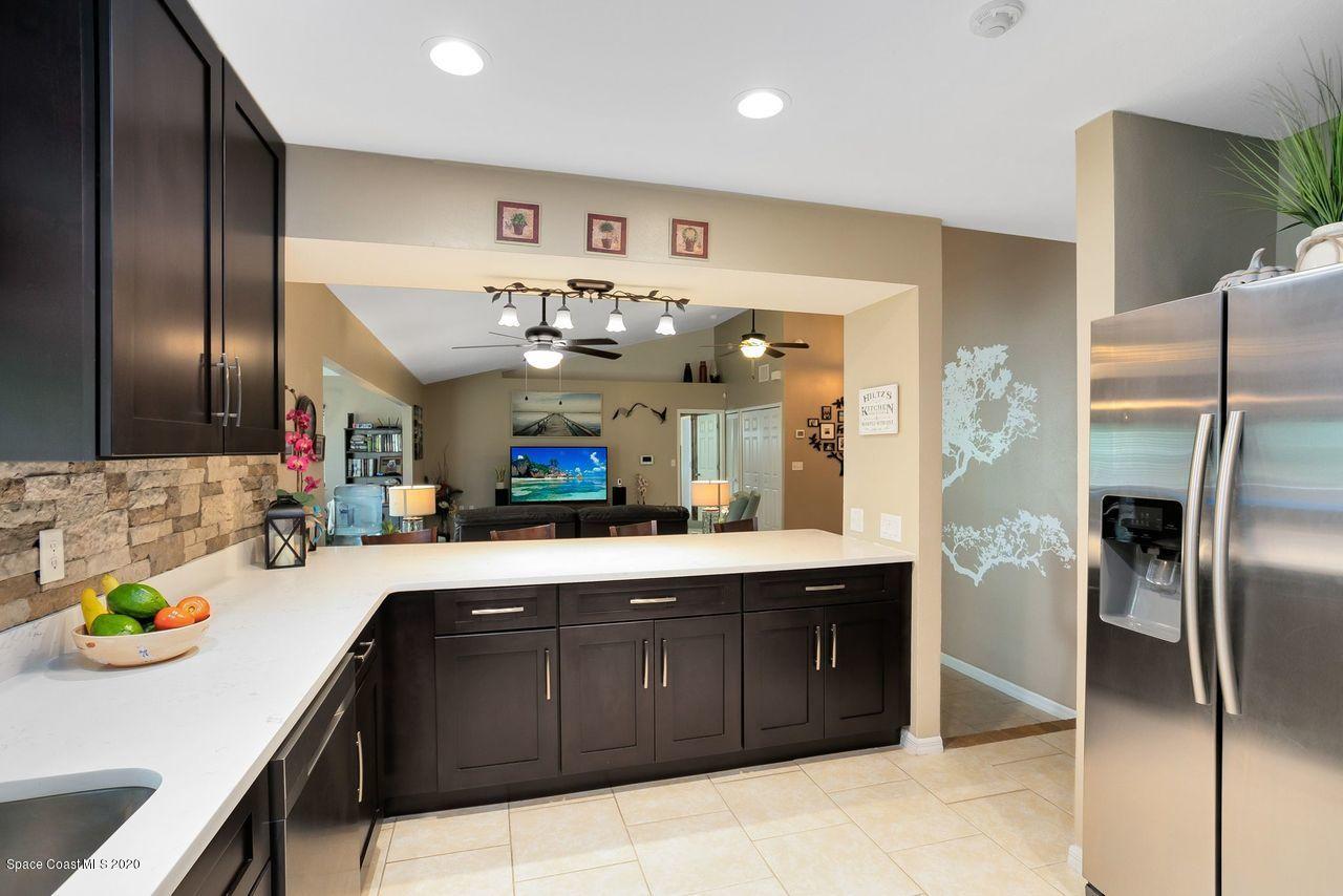 689 Bryant Road Palm Bay, FL 32908 - Photo 8 of 27 a kitchen with stainless steel appliances granite countertop a sink and a refrigerator