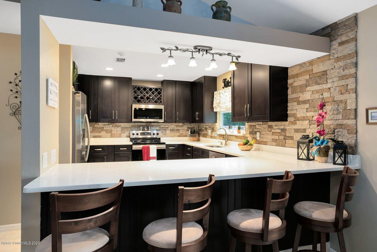 689 Bryant Road Palm Bay, FL 32908 - Photo 9 of 27 a kitchen with a dining table chairs sink and stove