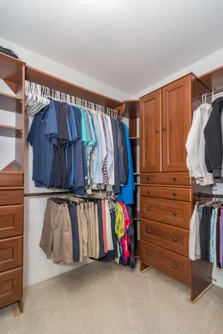 a view of walk in closet with clothes and shoes