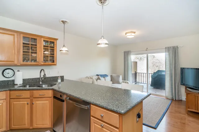 a kitchen with granite countertop a sink a counter top space and cabinets