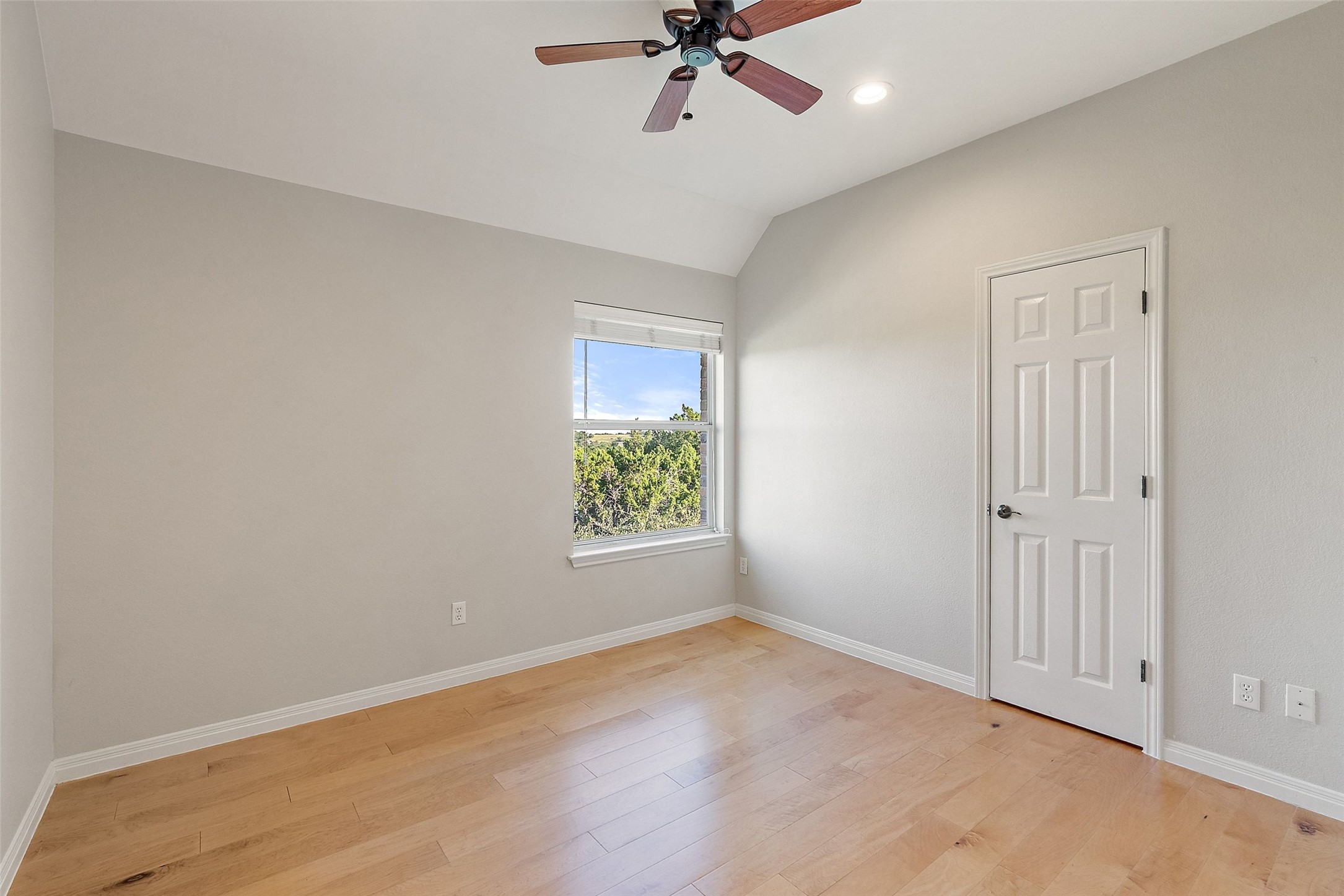 8215 Dark Ridge Cove Austin, TX 78737 - Photo 28 of 40 The second guest room features hardwood flooring, a ceiling fan, large closet, and hill country views.
