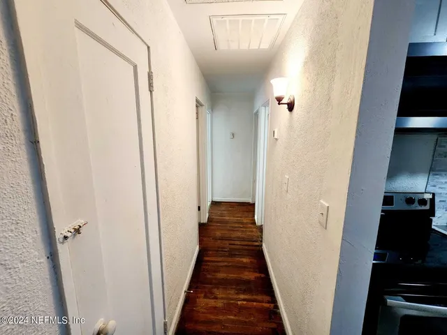 a view of a hallway with wooden floor and staircase