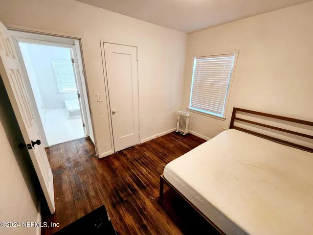 a bedroom with a bed and wooden floor