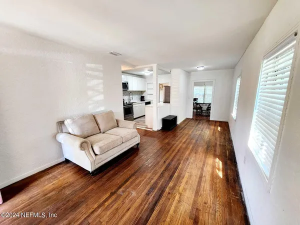 a living room with furniture and a wooden floor