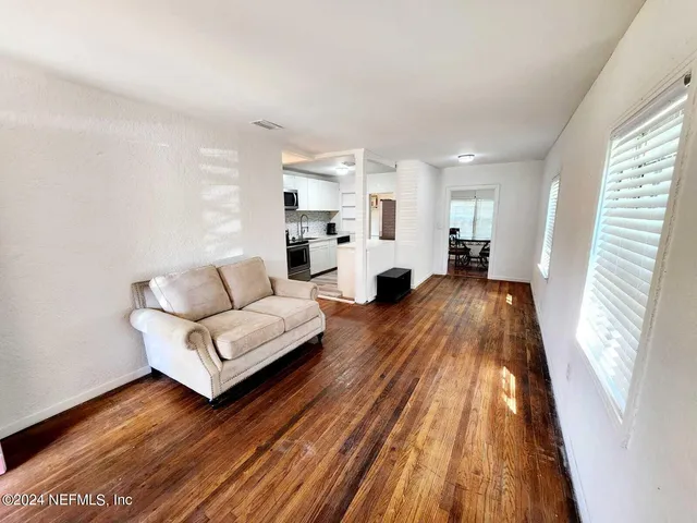 a living room with furniture and a wooden floor