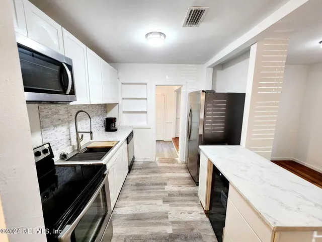 a kitchen with a sink a stove and refrigerator