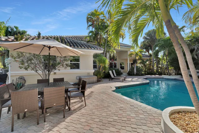 a view of a patio with chairs and a table under an umbrella