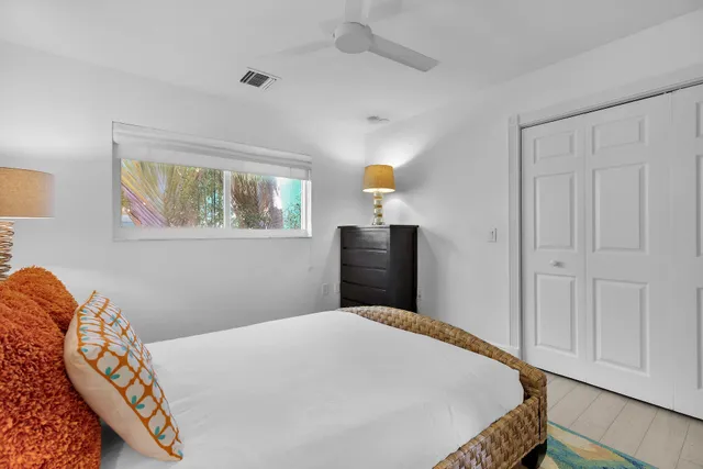 a bedroom with a bed and a lamp on dresser