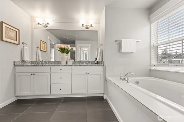 a spacious bathroom with a granite countertop sink a mirror and a shower