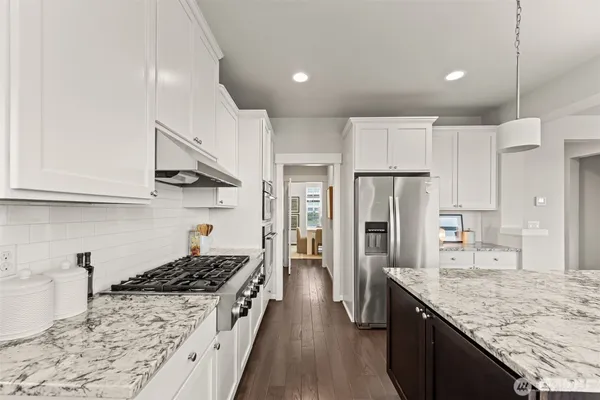 a kitchen with stainless steel appliances granite countertop a sink stove and refrigerator