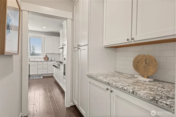 a kitchen with granite countertop white cabinets and sink