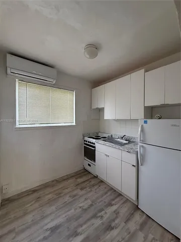 a kitchen with granite countertop a refrigerator stove top oven and sink