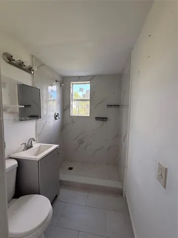 a bathroom with a toilet a sink and mirror